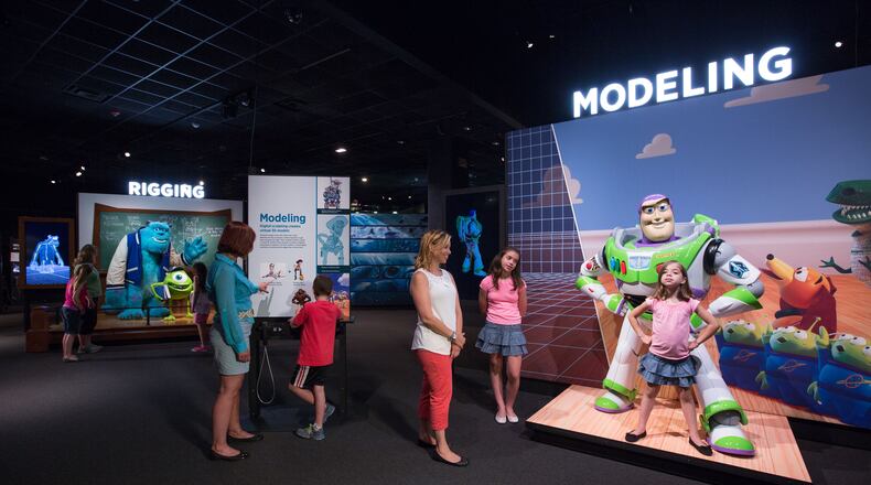 Visitors pose with human-sized models of some of their favorite Pixar characters, including Buzz Lightyear and Mike & Sulley. CONTRIBUTED