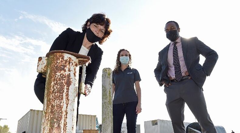 From left: Treva Bashore, restoration program manager, 88th Air Base Wing Civil Engineer Center; Rebecca Mora, project manager, AECOM; and Amir Mott, deputy director, 88th Civil Engineer Group, discuss a monitoring well at the fire training area of Wright-Patterson Air Force Base Sept. 29. Personnel from the 88th CEG are leading a pilot study of new remediation techniques that can remove polyfluoroalkyl substances from contaminated groundwater. U.S. AIR FORCE PHOTO/TY GREENLEES