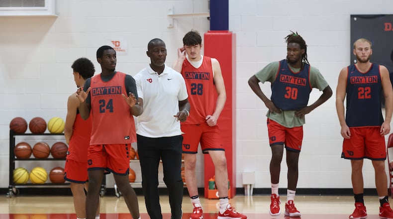 Dayton's Anthony Grant works with Kobe Elvis, Javon Bennett and other players at practice on Wednesday, Aug. 2, 2023, at the Cronin Center. David Jablonski/Staff