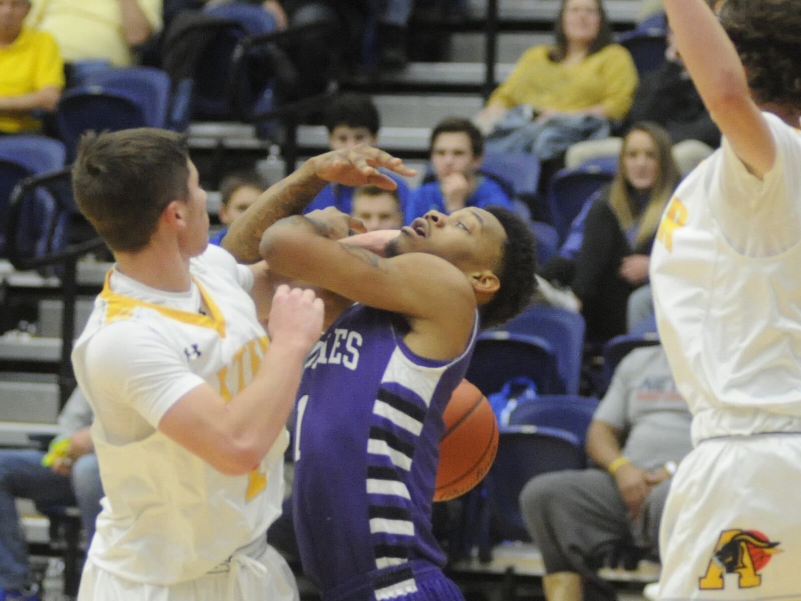 Middletown’s Nelson Rutledge (center) gets whacked by Alter’s Robby Ruffolo on Monday night during the Premier Health Flyin’ to the Hoop at Fairmont’s Trent Arena. MARC PENDLETON/STAFF
