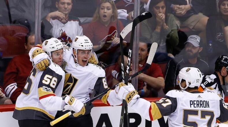 Vegas Golden Knights defenseman Nate Schmidt (88) celebrates his goal scored against the Arizona Coyotes with Golden Knights left wing Erik Haula (56) and Golden Knights left wing David Perron (57) during the third period of an NHL hockey game Saturday, Oct. 7, 2017, in Glendale, Ariz. The Golden Knights defeated the Coyotes 2-1 in overtime. (AP Photo/Ross D. Franklin)