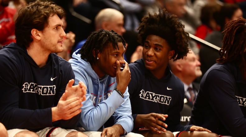 Dayton's Malachi Smith, second from left, talks to Marvel Allen during a game against Longwood on Saturday, Dec. 30, 2023, at UD Arena. David Jablonski/Staff