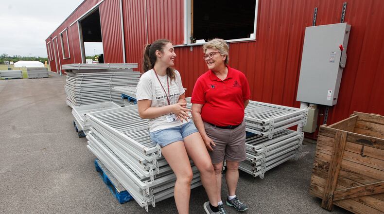 Charity Moore, a KNL 4-H Club member from Germantown, talks with Betty Wingerter, Ohio State University Extension 4-H youth development educator, during preparations Friday for the  Montgomery County Fair. CHRIS STEWART / STAFF