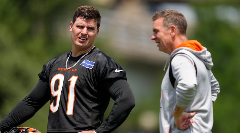 Cincinnati Bengals' Trey Hendrickson (91) speaks with defensive coordinator Lou Anarumo during NFL football practice, Tuesday, June 4, 2024, in Cincinnati. (AP Photo/Jeff Dean)