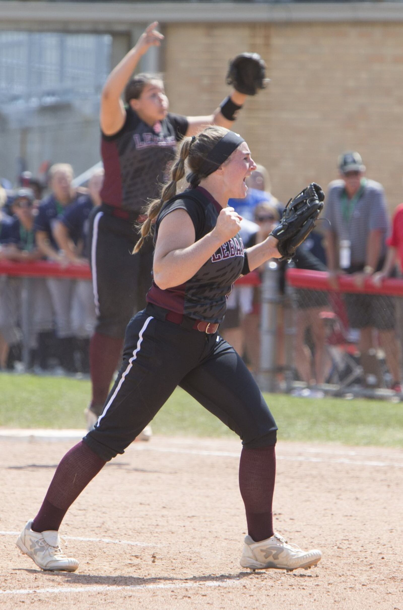 Lebanon pitcher Taylor Lewis and first baseman Alexis Strother celebrate the last out in Thursday’s Division I state semifinal victory over North Canton Hoover at Firestone Stadium in Akron. ROBERT ROSSITER/THE CANTON REPOSITORY
