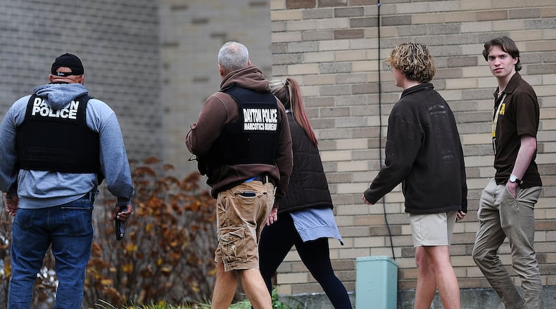 Members of the Kettering and Dayton Police Departments escort Archbishop Alter High School students to the gym Wednesday, Nov. 8, 2023 after a report of shots fired at the school. MARSHALL GORBY\STAFF