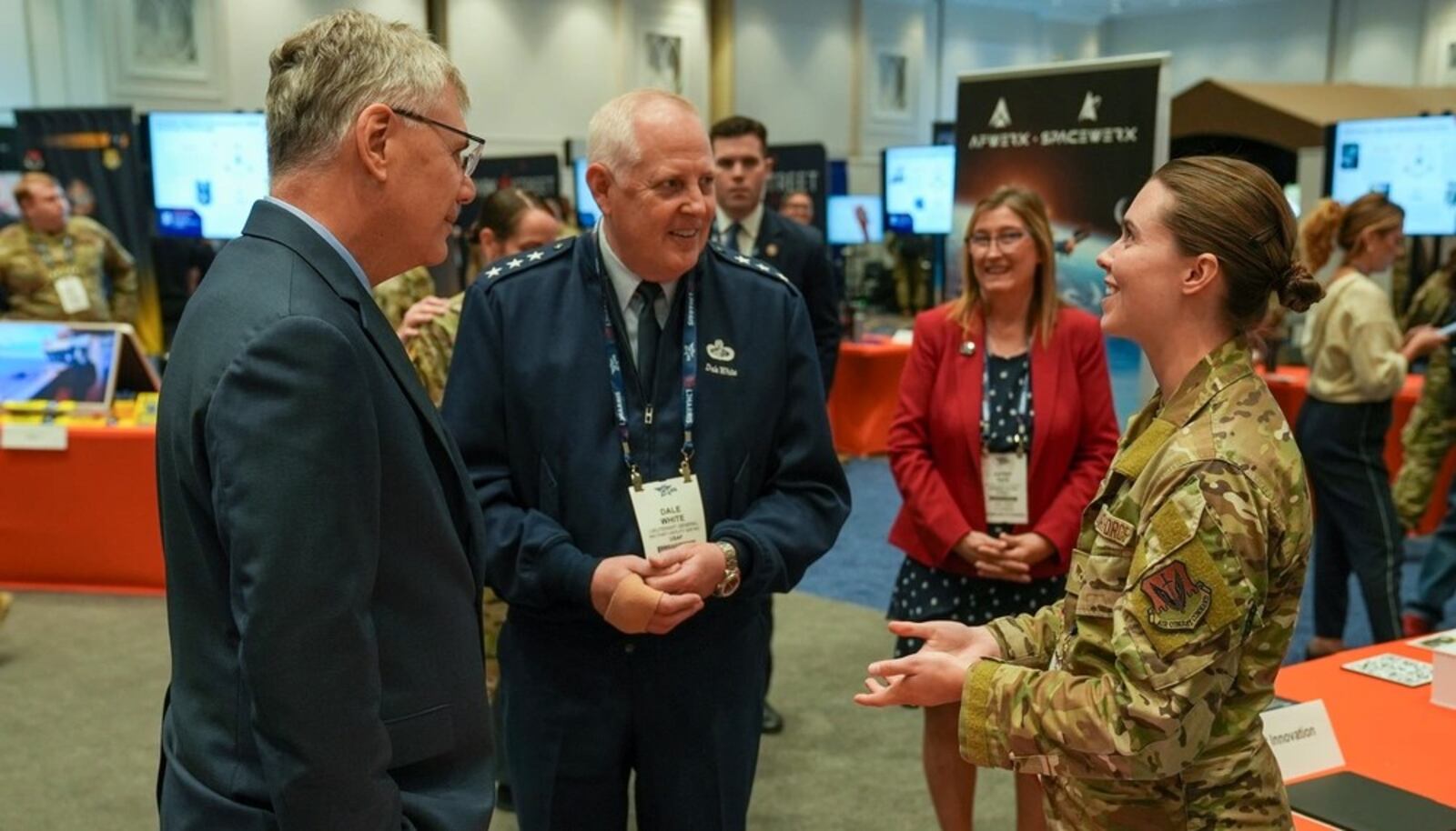 Senior Airman Erika Gustafson, AFWERX Spark (right), briefs Troy Meink, secretary of the Air Force (left), and Lt. Gen. Dale White (middle), Oﬃce of the Assistant Secretary of the Air Force for Acquisition, Technology, and Logistics military deputy, during the Air, Space and Cyber Conference in National Harbor, Md., on Sept. 24, 2025. Air Force photo by Matthew Clouse.
