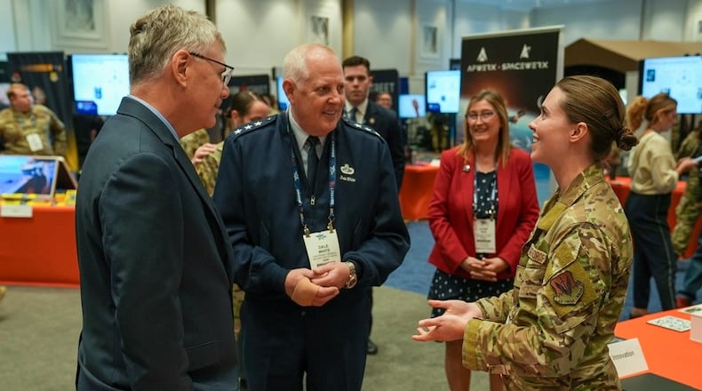 Senior Airman Erika Gustafson, AFWERX Spark (right), briefs Troy Meink, secretary of the Air Force (left), and Lt. Gen. Dale White (middle), Office of the Assistant Secretary of the Air Force for Acquisition, Technology, and Logistics military deputy, during the Air, Space and Cyber Conference in National Harbor, Md., on Sept. 24, 2025. Air Force photo by Matthew Clouse.