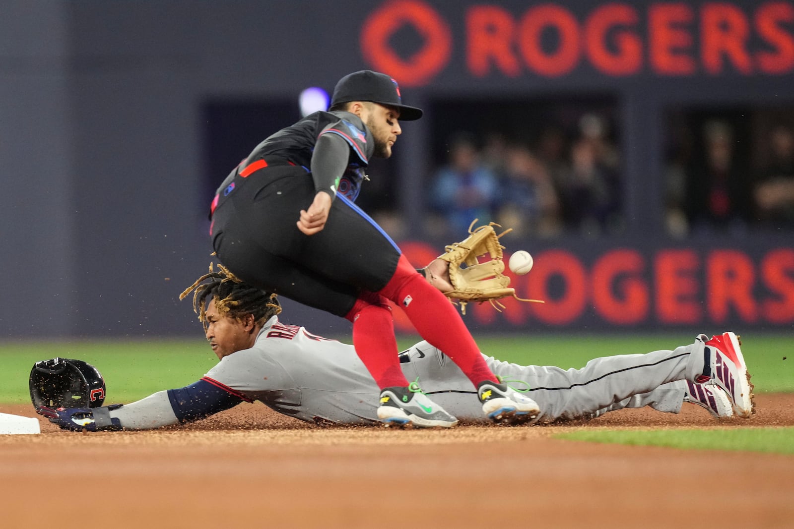 Cleveland Guardians' Jose Ramirez steals second base in front of Toronto Blue Jays shortstop Bo Bichette during the first inning of a baseball game in Toronto on Friday, May 2, 2025. (Chris Young/The Canadian Press via AP)