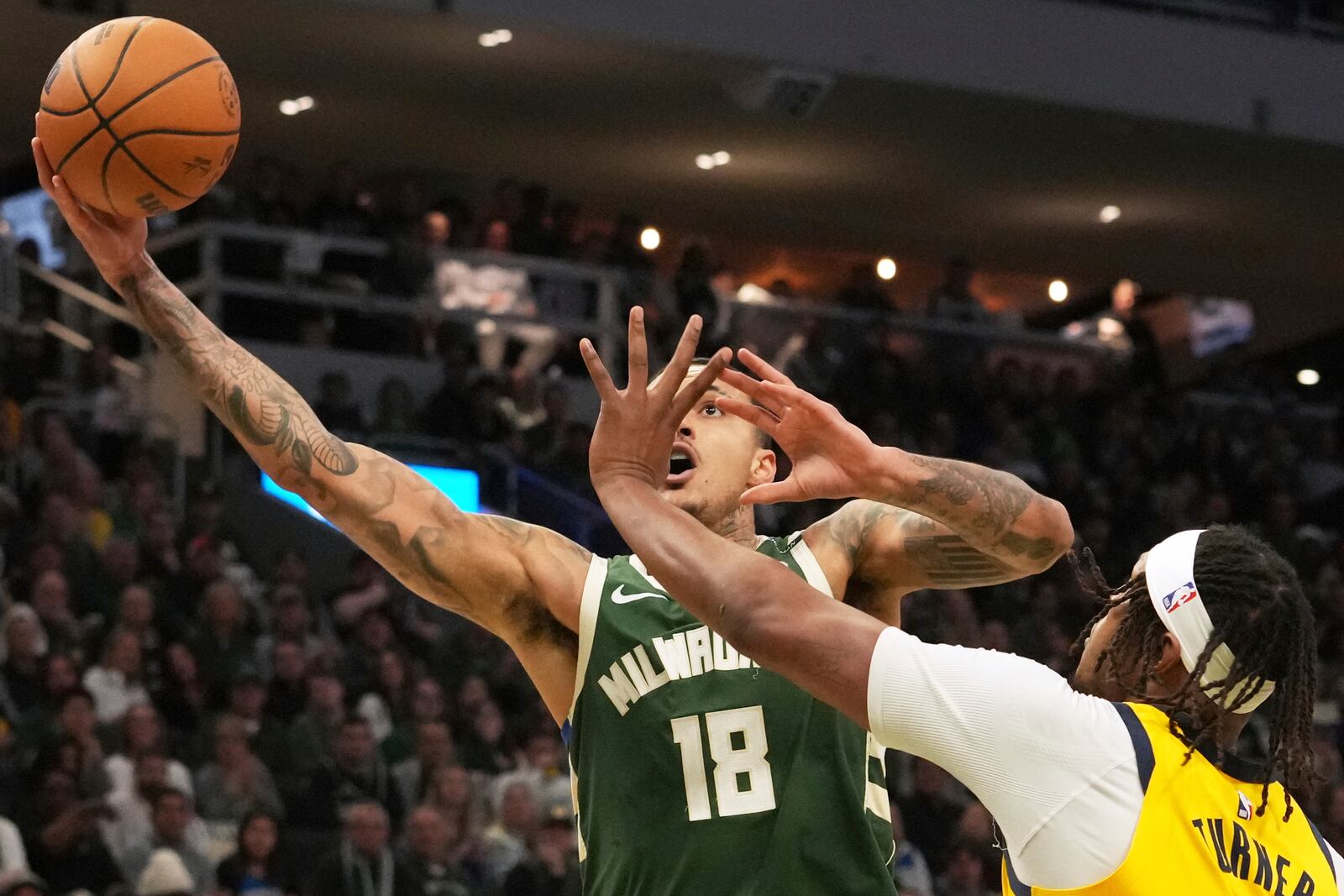 Milwaukee Bucks forward Kyle Kuzma, left, drives to the basket against Indiana Pacers center Myles Turner, right, during the first half in Game 3 of an NBA basketball first-round playoff series Friday, April 25, 2025, in Milwaukee. (AP Photo/Nam Y. Huh)
