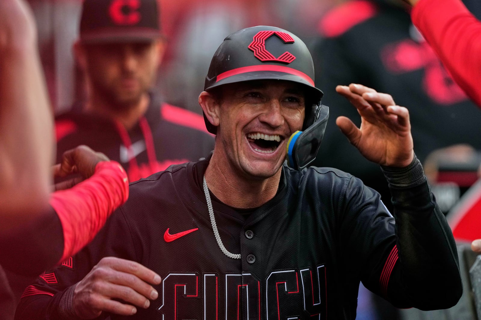 Cincinnati Reds Austin Hays celebrates in the dugout after scoring on a wild pitch from Chicago Cubs pitcher Matthew Boyd in the third inning of a baseball game, Friday, May 23, 2025, in Cincinnati. (AP Photo/Carolyn Kaster)