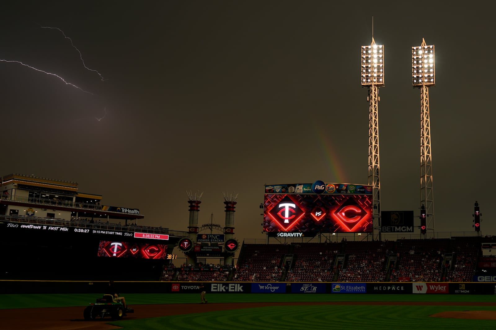 As the sun breaks through, a rainbow and lighting are seen over Great American Ball Park at the end of a weather delay before a baseball game between the Cincinnati Reds and the Minnesota Twins, Wednesday, June 18, 2025, in Cincinnati. (AP Photo/Carolyn Kaster)