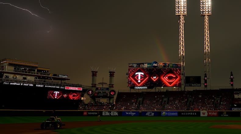 As the sun breaks through, a rainbow and lighting are seen over Great American Ball Park at the end of a weather delay before a baseball game between the Cincinnati Reds and the Minnesota Twins, Wednesday, June 18, 2025, in Cincinnati. (AP Photo/Carolyn Kaster)