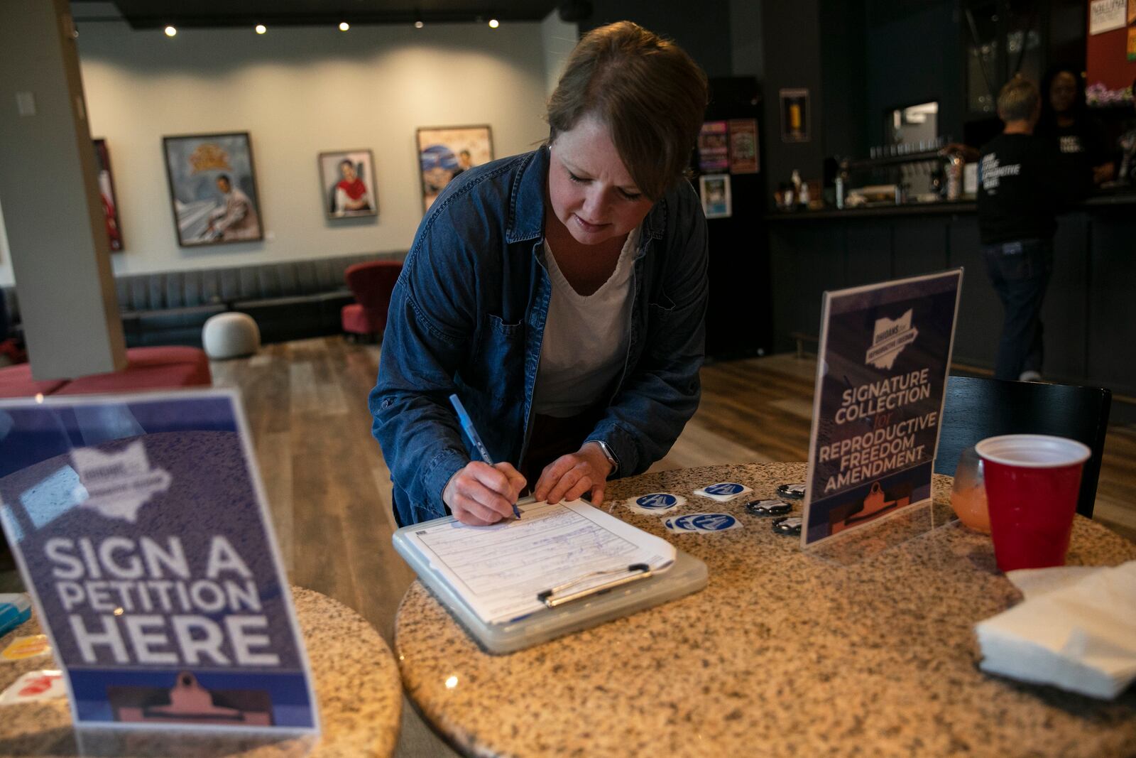
                        An Ohio voter, Lysha Ingle, signs a petition to place an amendment protecting abortion rights in the state constitution on the ballot, in Cincinnati, April, 21, 2023. After abortion rights supporters swept six ballot measures last year, Republican legislatures seek to make it harder to get on the ballot, and harder to win if there is a vote. (Maddie McGarvey/The New York Times)
                      