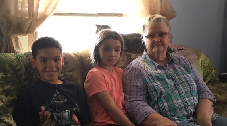 From left, Chance Blue, 8, his sister, Skylar Weaver, 10, and their great-grandmother, Nita Coburn, 69, are attending the Cincinnati Reds game with members of the Middletown Division of Police. ED RICHTER/STAFF
