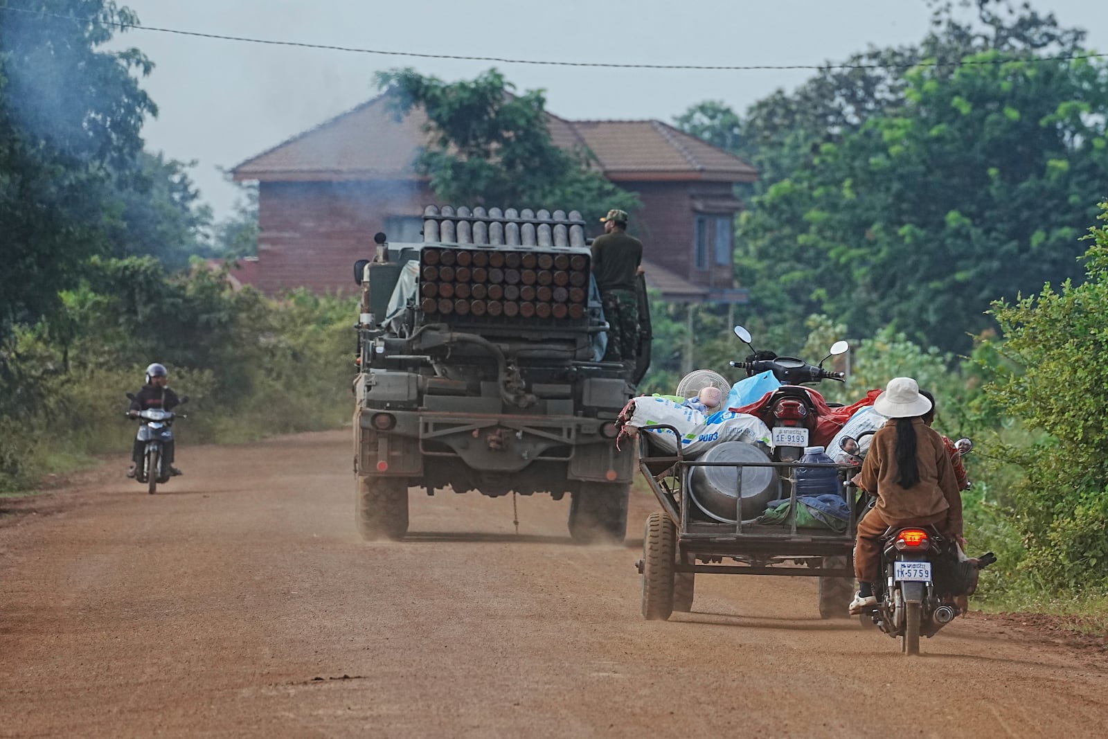Cambodians drive behind a military vehicle for evacuation in Oddar Meanchey province, Cambodia, Friday, July 25, 2025, as Thai and Cambodian soldiers have clashed along the border between their countries in a major escalation. (AP Photo/Heng Sinith)