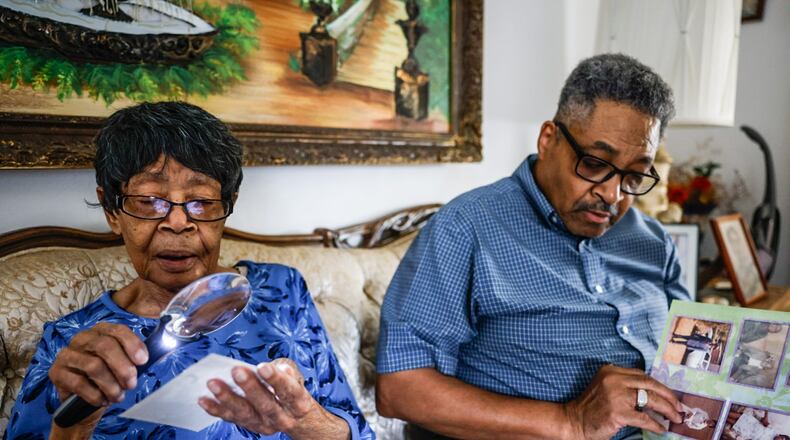 Alberta Jones and her son Carl Ogldtree go through family photos on Alberta's 105th birthday at her home in Trotwood June 19, 2024. JIM NOELKER/STAFF