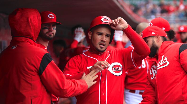 The Reds Eugenio Suarez returns to the dugout after scoring against the Cubs on Monday, April 2, 2018, at Great American Ball Park in Cincinnati. David Jablonski/Staff