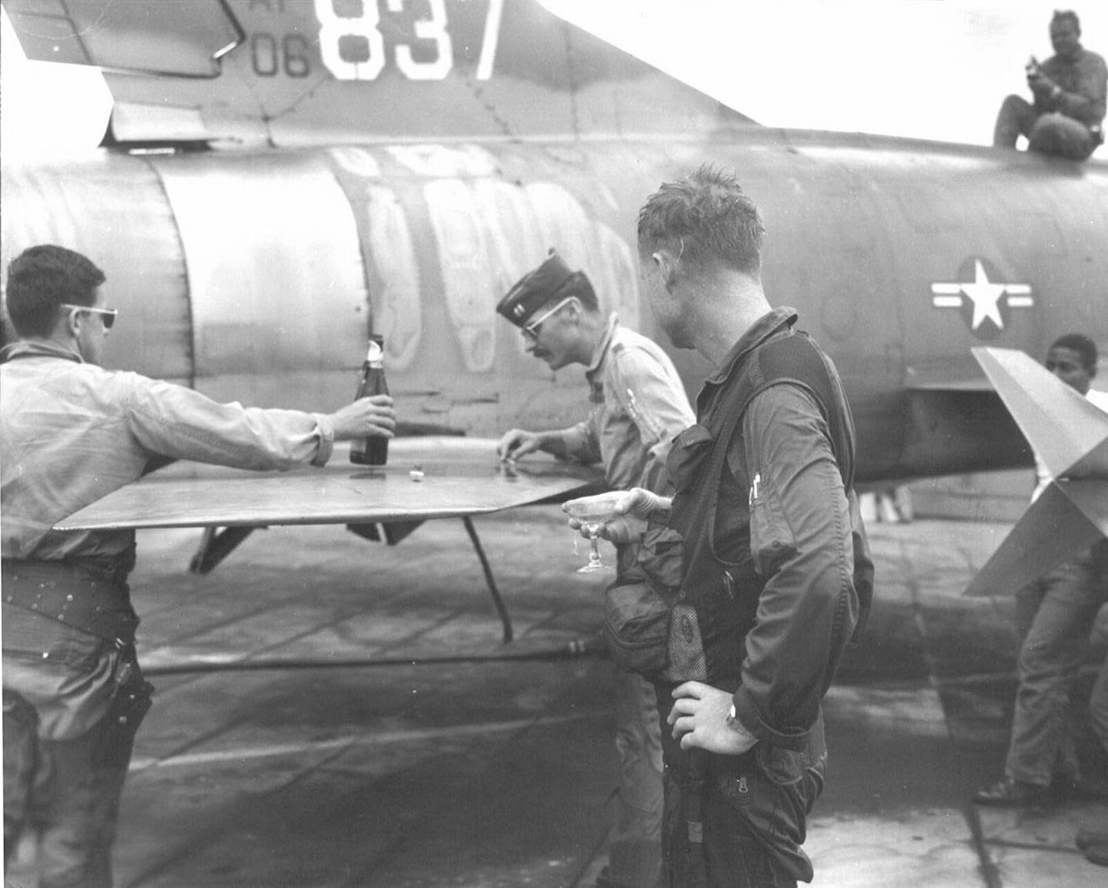On March 18, 1968, Capt. James Ed Risinger finished his Misty FAC tour in the F-100F that is on display at the National Museum of the U.S. Air Force (S/N 56-3837). Capt. Risinger, holding a glass of champagne, celebrates his 58th and final mission. On the left is Capt. Brian Williams and inspecting bullet damage is Capt. Richard Rutan. (U.S. Air Force photo)