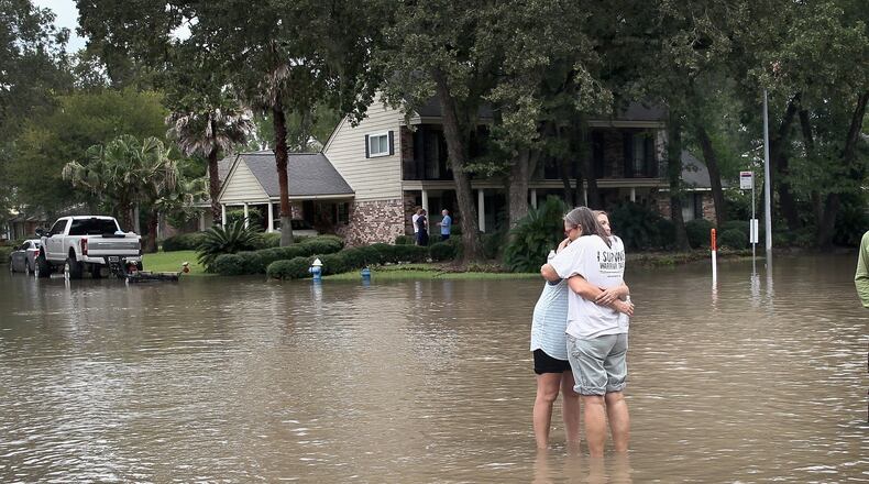HOUSTON, TX - AUGUST 30: Friends reunite in the middle of a flooded intersection as water continues to rise in their neighborhood following Hurricane Harvey on August 30, 2017 in Houston, Texas. Harvey, which made landfall north of Corpus Christi August 25, has dumped nearly 50 inches of rain in and around Houston. (Photo by Scott Olson/Getty Images) *** BESTPIX ***
