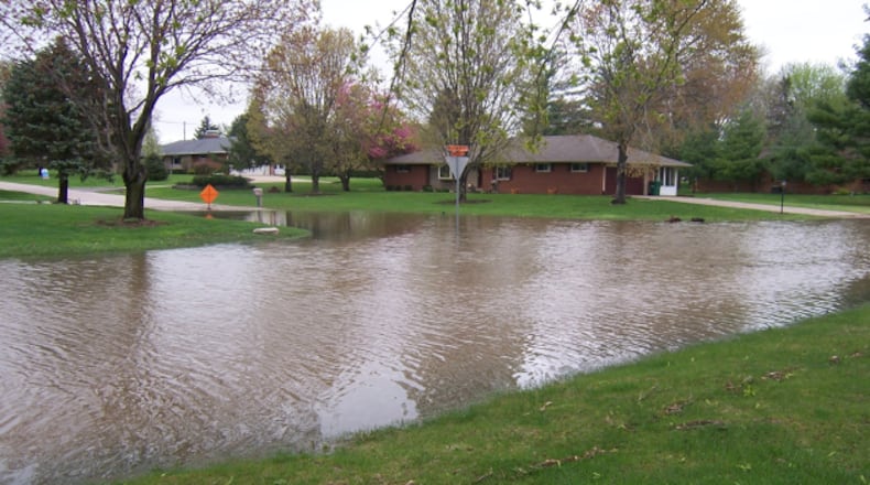 A heavily flooded neighborhood along Willowcrest Drive in Beavercreek. A sign in the back warns of standing water.