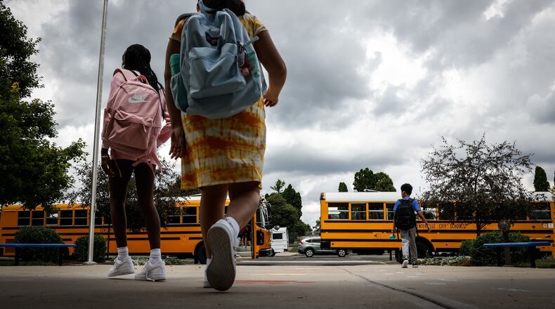 Children at Cline Elementary School in Centerville load into buses after the first day of school Wednesday August 18, 2021. All of the kids were wearing masks. JIM NOELKER/STAFF