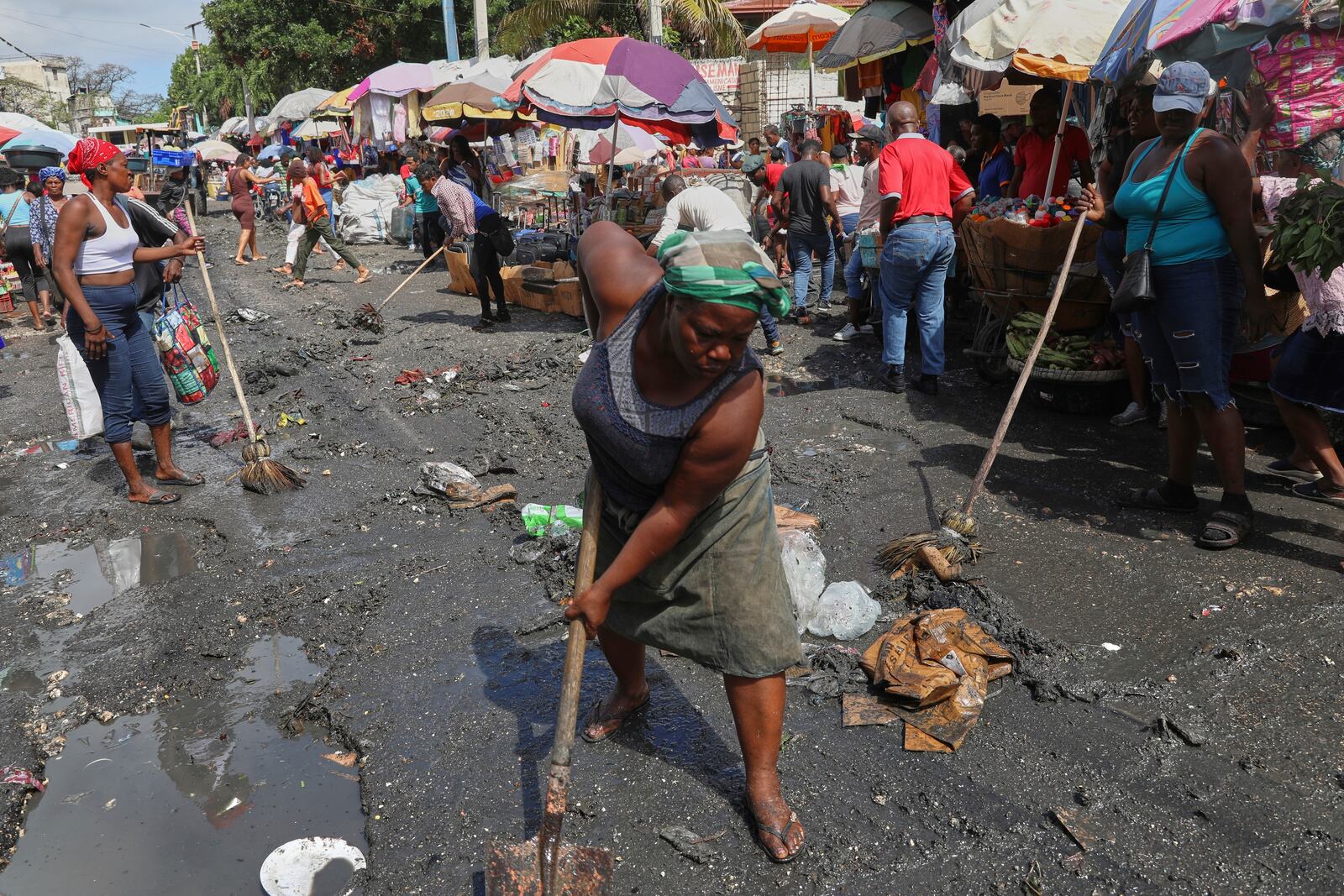 Vendors clean a street before starting to sell their goods in the Petion-ville neighborhood of Port-au-Prince, Haiti, Friday, May 16, 2025. (AP Photo/Odelyn Joseph)