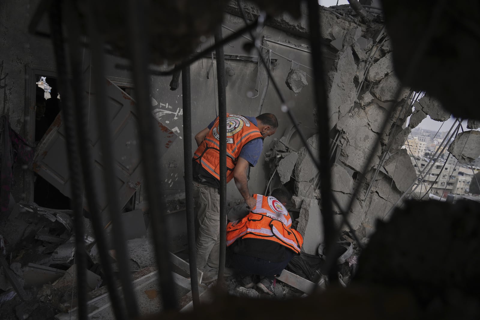 Palestinians civil defense workers search through the debris following an Israeli airstrike on a residential building in Gaza City, Thursday, April 24, 2025. (AP Photo/Jehad Alshrafi)