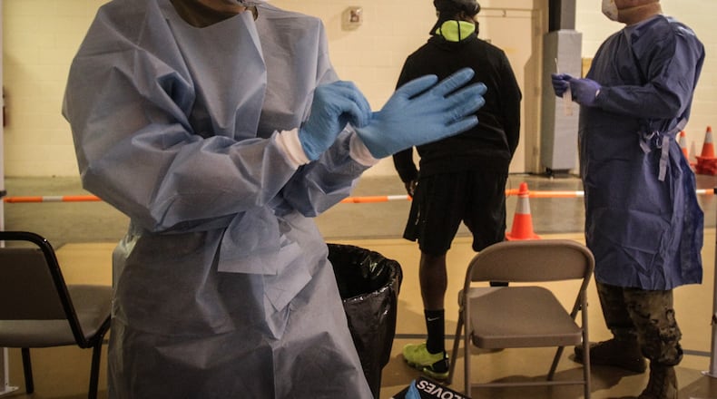 Ohio National Guard Specialist, Kelsey Sherlock left and Sgt. Nicholas Robinson with the Ohio National Guard, administers a COVID-19 test at Bethesda Temple on Salem Wednesday Dec. 9, 2020. Montgomery County Public Health organized the pop-up test.