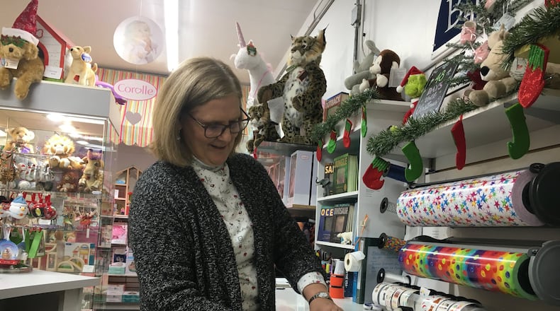 Cathy Tapogna, owner of Blue Turtle Toys, wraps a present. One of the most popular items in the store are the Charlie Bears. STAFF PHOTO / HOLLY SHIVELY