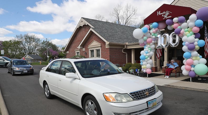 The car parade in Huber Heights will celebrate Wayne High School’s gradution. Pictured is a car parade for Ruth Bayley’s 100th birthday. Friends and family drove past her in front of the Hearth & Home care center. BILL LACKEY/STAFF