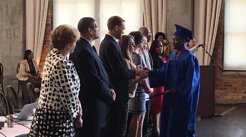 Dayton Public Schools leaders congratulate 2018 summer graduates at a school board meeting. JEREMY P. KELLEY / STAFF