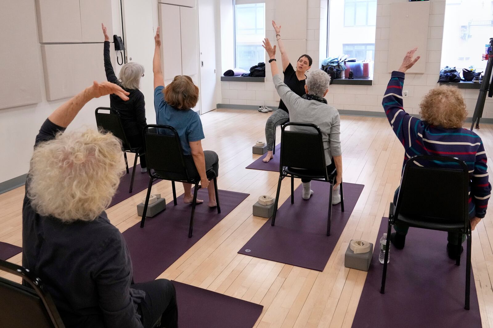 Whitney Chapman, background center, conducts a chair yoga class at the Marlene Meyerson JCC Manhattan, in New York, March 28, 2025. (AP Photo/Richard Drew)