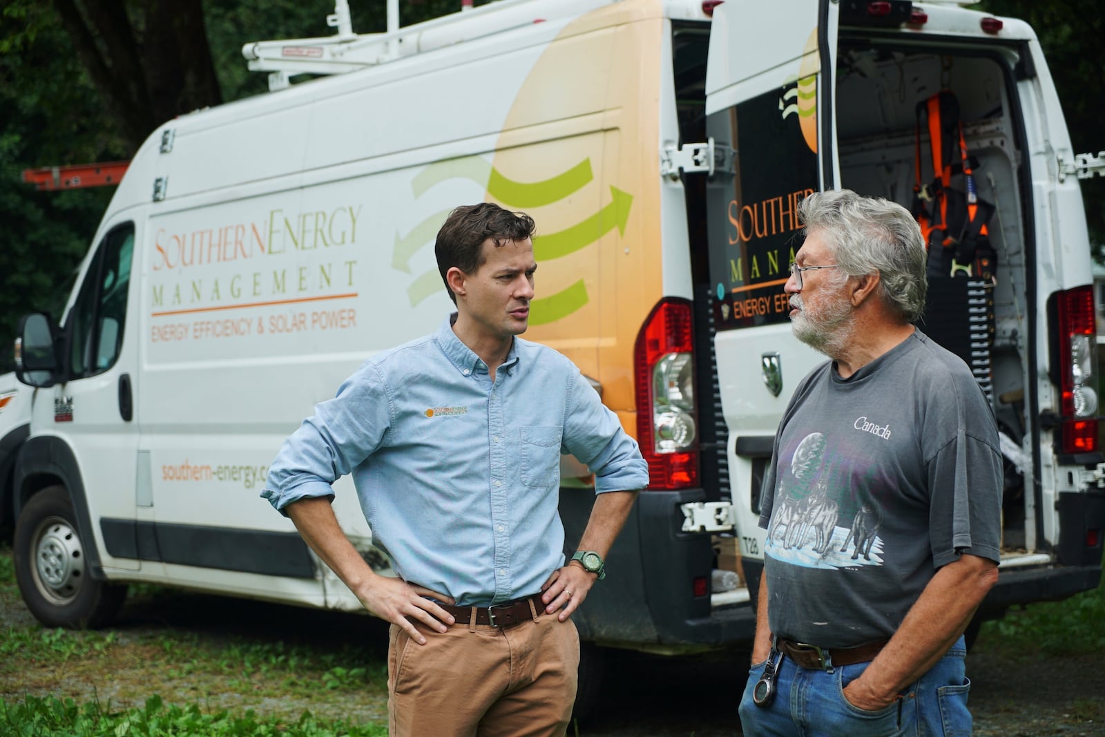 James Asbill, right, speaks with Will Etheridge, CEO of Southern Energy Management, as solar panels are installed on Asbill's home in Chapel Hill, N.C., Wednesday, July 2, 2025. (AP Photo/Allen G. Breed)