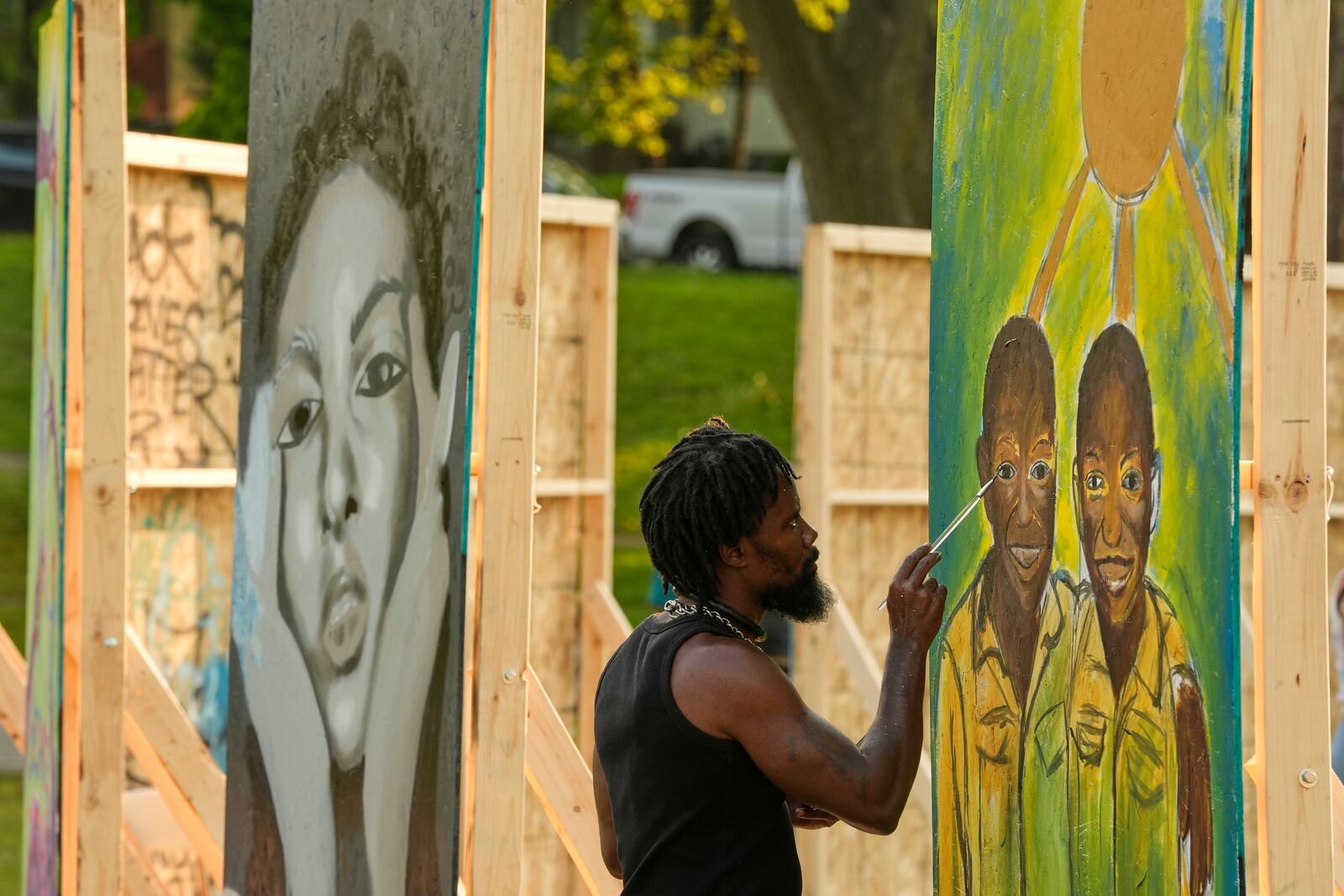Flahn Manly works on a painting in a park near George Floyd Square on the five-year anniversary of Floyd's death, Sunday, May 25, 2025, in Minneapolis. (AP Photo/Abbie Parr)