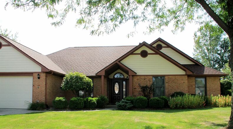 A partial brick wrap enhances the facade of this ranch home in Fairborn. Two columns support a cathedral-style covering above the front entrance. Boxwoods, a dwarf tree and various blooming plants fill the flowerbeds flanking the front entrance. Another wraps around the corner to the side yard and is filled with large sedum plants about ready to bloom. CONTRIBUTED PHOTOS BY KATHY TYLER