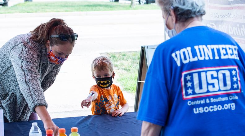 Alesya Flynn and her 5-year-old son Henry check out the variety of items available to them during the ‘USO-To-Go’ soft-reopening event at Wright-Patterson Air Force Base Sept. 16. Visitors were able to get salty, sweet and nutritious snacks, as well as bottled water and sports drinks, at no cost. The event was help in preparation for the USO’s planned grand re-opening in October. U.S. Air Force photo/Wesley Farnsworth