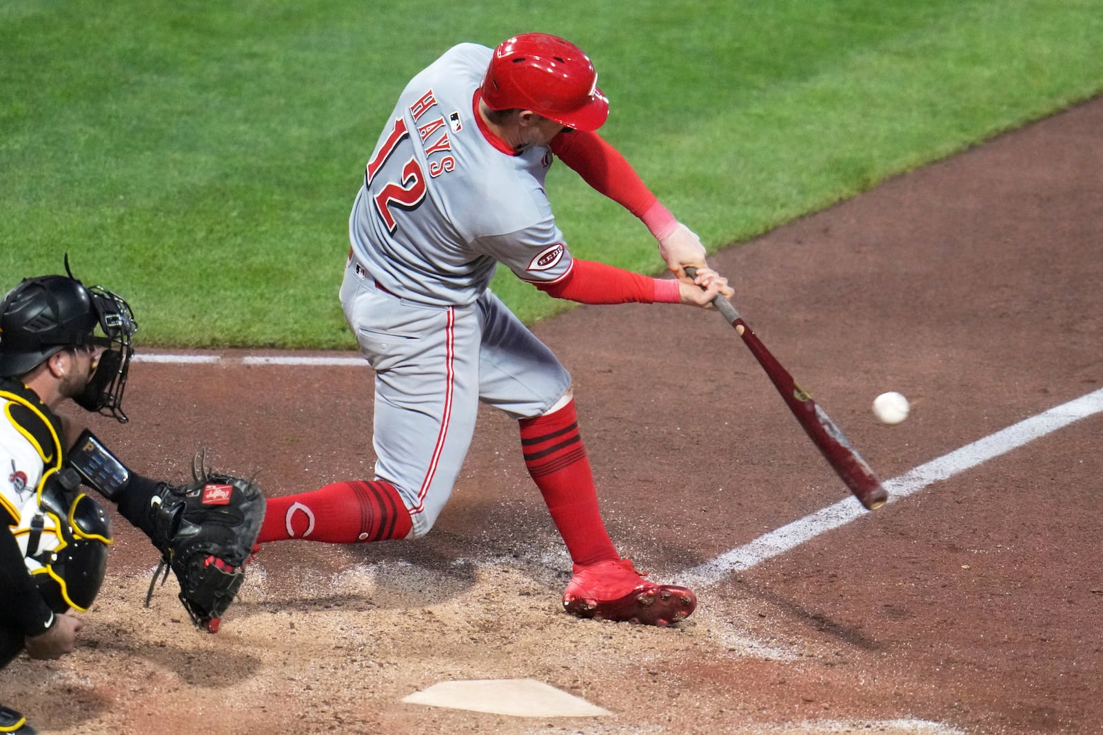 Cincinnati Reds' Austin Hays (12) singles off Pittsburgh Pirates pitcher David Bednar, driving in a run, during the eighth inning of a baseball game in Pittsburgh, Monday, May 19, 2025. (AP Photo/Gene J. Puskar)
