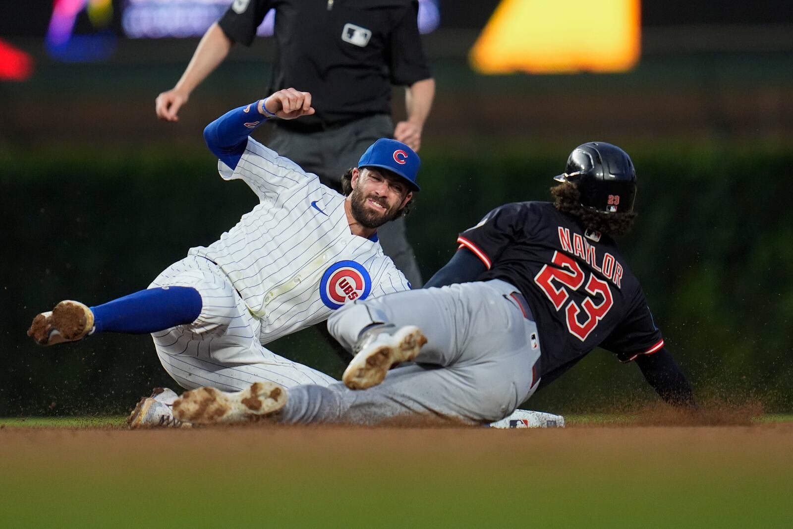 Chicago Cubs shortstop Dansby Swanson (7), left, catches Cleveland Guardians' Bo Naylor (23) stealing second during the fifth inning of a baseball game Thursday, July 3, 2025, in Chicago. (AP Photo/Erin Hooley)