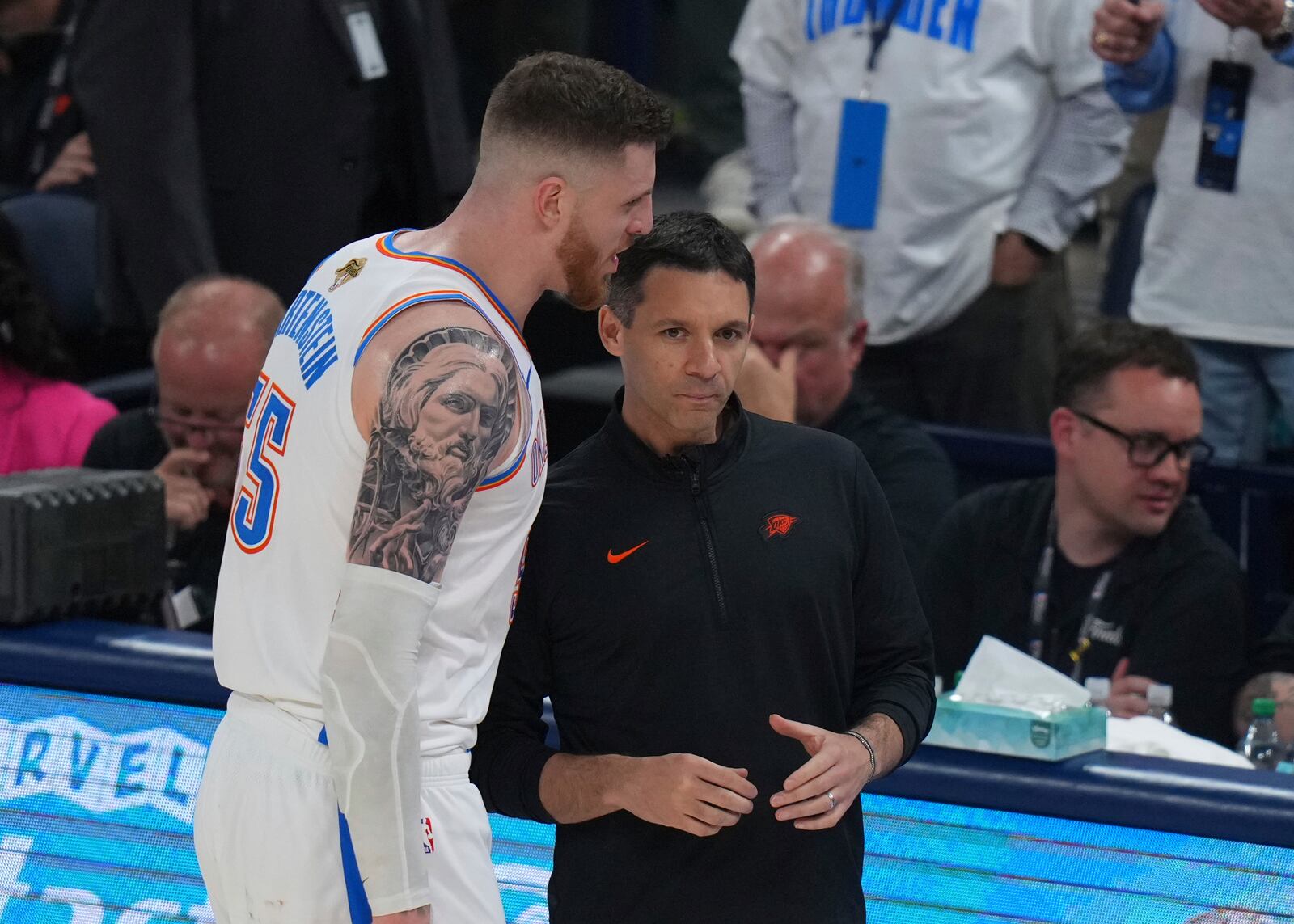 Oklahoma City Thunder center Isaiah Hartenstein (55) talks with head coach Mark Daigneault during the second half of Game 1 of the NBA Finals basketball series against the Indiana Pacers Thursday, June 5, 2025, in Oklahoma City. (AP Photo/Nate Billings)
