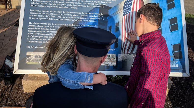 Lt. Chris Ferguson a Beavercreek firefighter attended the 911 anniversary ceremony with his children, Ellie Ferguson and Aiden Ferguson. JIM NOELKER/STAFF