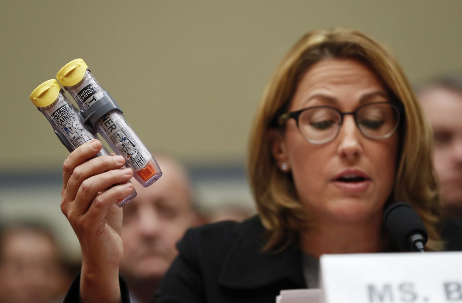 In this Wednesday, Sept. 21, 2016, file photo, Mylan CEO Heather Bresch holds up EpiPens while testifying in a hearing before the U.S. House Oversight Committee. Last October, Mylan agreed to pay $465 million to settle Justice Department allegations that it overbilled Medicaid for its life-saving EpiPen allergy injection. (AP Photo/Pablo Martinez Monsivais, File)