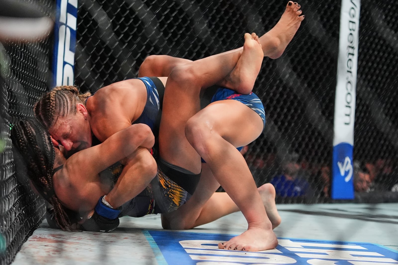Kayla Harrison, right, grapples with Julianna Peña during the second round of a women's bantamweight bout at the UFC 316 mixed martial arts event Sunday, June 8, 2025 in Newark, N.J. (AP Photo/Frank Franklin II)