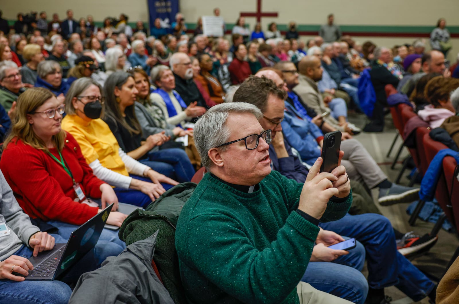 An audience member films the estimated 1,200 attendees of Here We Stand: Faith Leaders for Immigration Justice & Family Unity at St. John Missionary Baptist Church on Monday, Feb. 2, 2026, in Springfield. The venue was over capacity as pastors, faith leaders and community members gathered to pray and call for the extension of Temporary Protected Status, which is scheduled to expire on Tuesday, Feb. 3, 2026. JOSEPH COOKE/STAFF