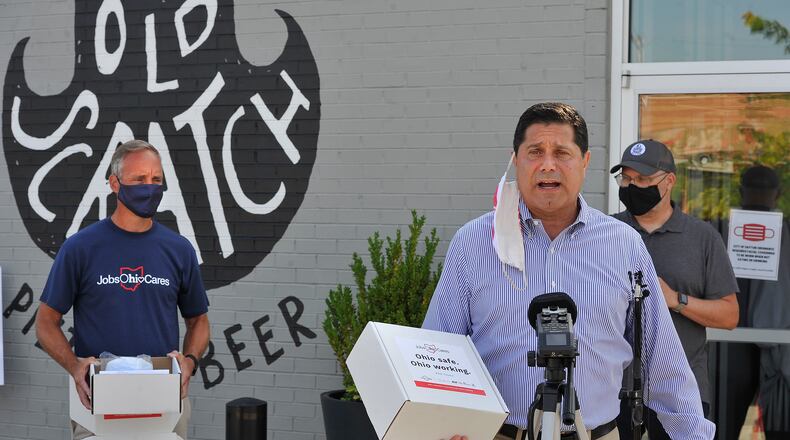 J.P. Nauseef, JobsOhio President and CEO, talks to the media Tuesday at the Old Scratch Pizza and Beer along with Jeff Hoaglans, DDC president and CEO, right and Eric Sollar, owner of Old Scratch Pizza. The Dayton Development Coalition Partners with JobsOhio distributed PPE toolkits to regional small businesses. Each kit included 100 3-ply masks, 10 KN-95 masks and a 24-ounce bottle of hand sanitizer. MARSHALL GORBY\STAFF