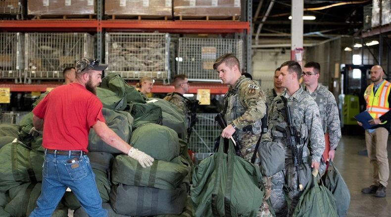 While processing through a deployment line, Airmen from Wright-Patterson Air Force Base place their bags on a pallet for a simulated short-notice deployment during a base readiness assessment at Wright-Patterson Air Force Base Oct. 8. Base readiness assessments are routinely held to practice procedures for responding to emergencies and to show the base’s readiness to rapidly deploy. (U.S. Air Force photo/Michelle Gigante)