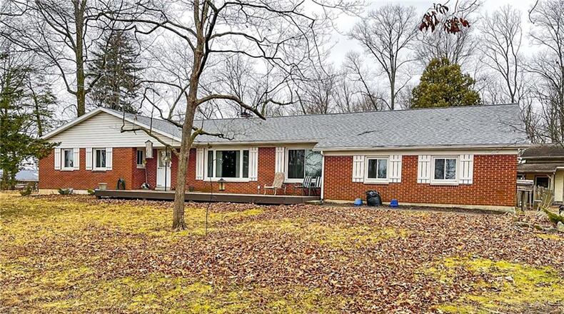 The front of the brick ranch features a new wooden deck and a gravel driveway leading to the two-car attached and two-car detached garages. Contributed photos