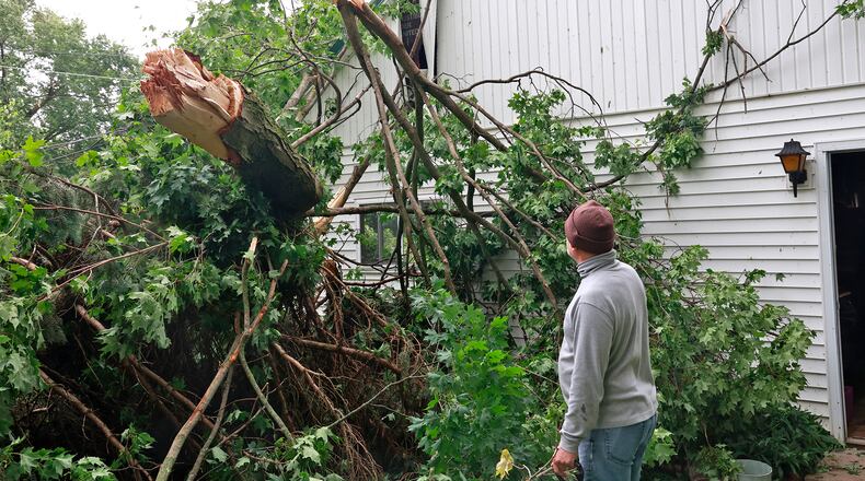 Tony Mitchell, a Christiansburg resident, surveys the damage to his garage Monday, June 12, 2023. A storm Sunday night toppeled trees and knocked out power in the Champaign County town. BILL LACKEY/STAFF