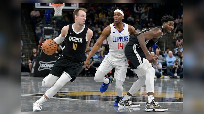 Memphis Grizzlies guard Luke Kennard (10) drives as Los Angeles Clippers guard Terance Mann (14) works around a screen by Grizzles' Jaren Jackson Jr. during the second half of an NBA basketball game Friday, Feb. 23, 2024, in Memphis, Tenn. (AP Photo/Brandon Dill)