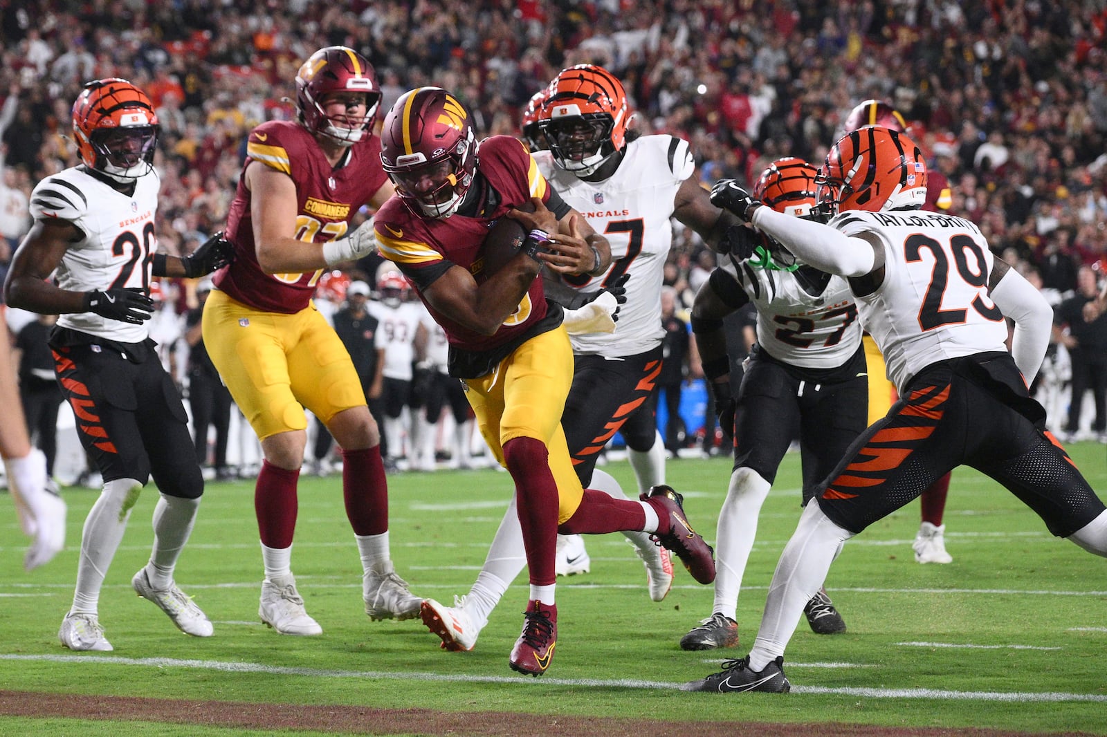 Washington Commanders quarterback Jayden Daniels scores on a touchdown run during the first half of a preseason NFL football game against the Cincinnati Bengals Monday, Aug. 18, 2025, in Landover, Md. (AP Photo/Nick Wass)